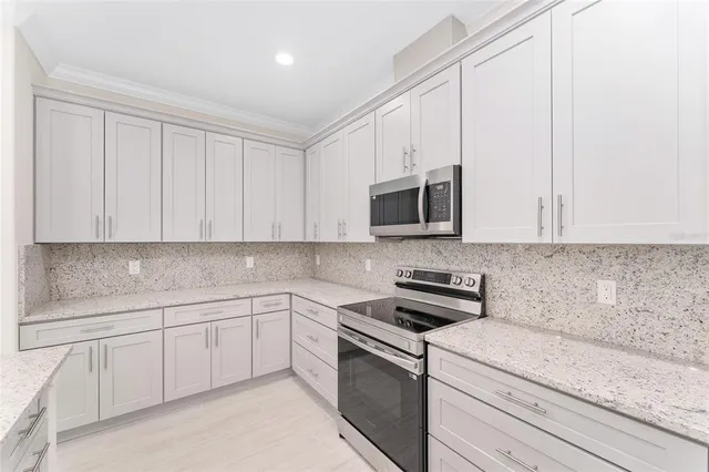 a kitchen with white cabinets stainless steel appliances and sink