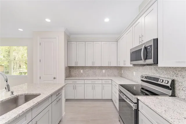 a kitchen with stainless steel appliances granite countertop a sink and a stove