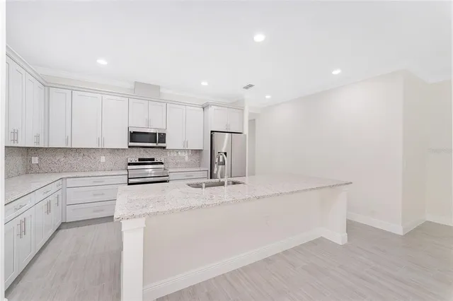 a kitchen with stainless steel appliances a refrigerator sink and stove