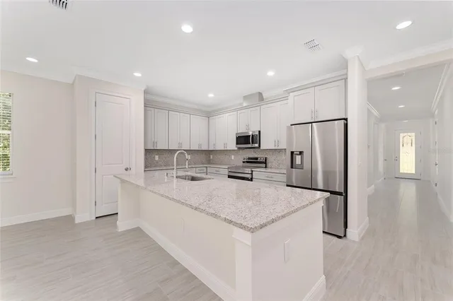 a kitchen with stainless steel appliances a refrigerator sink and microwave