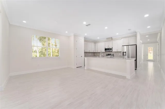 a view of kitchen with kitchen island sink refrigerator and window