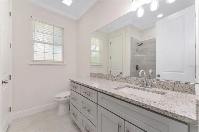 a bathroom with a granite countertop double vanity sink a mirror and a bathtub