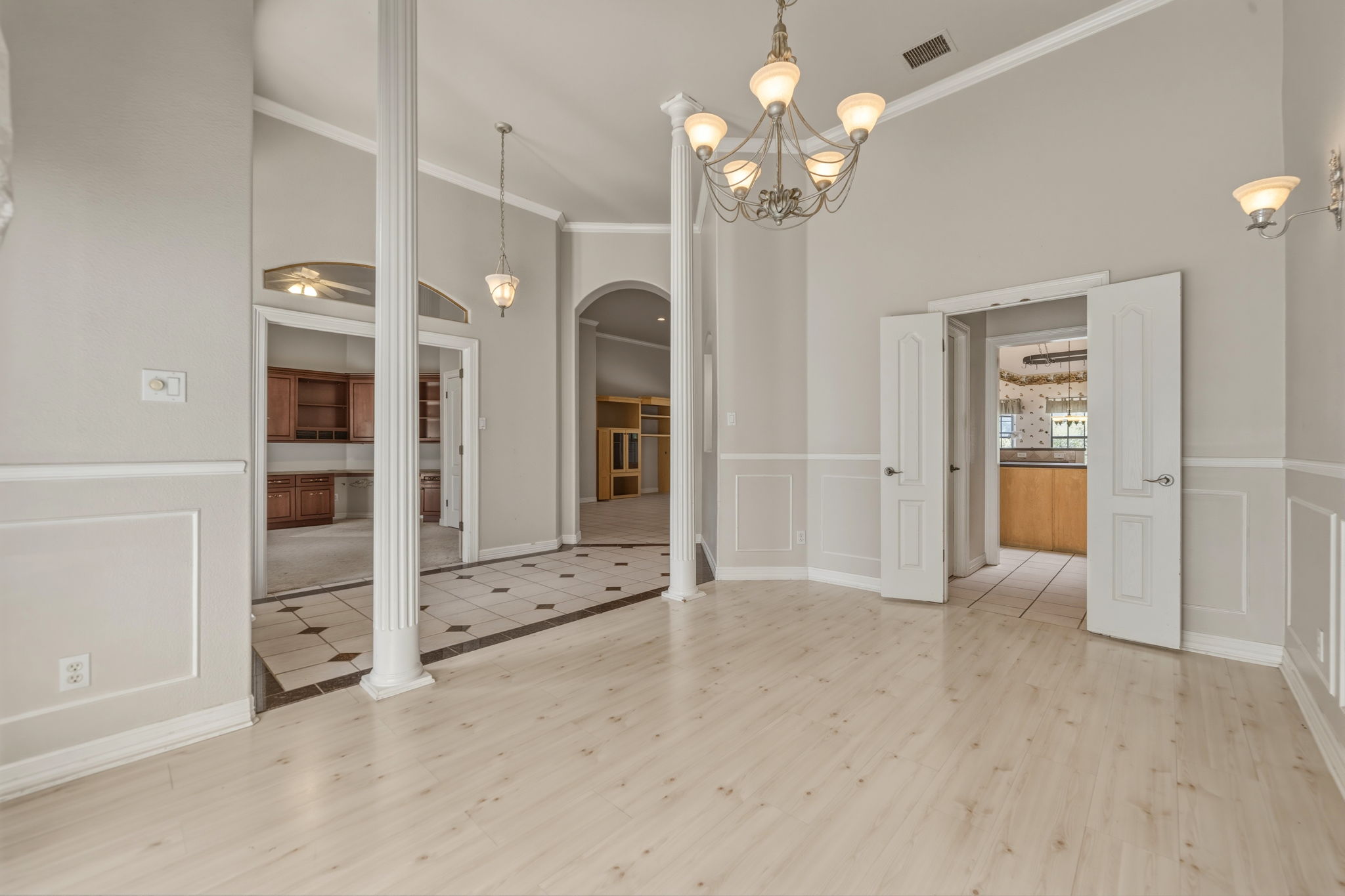 14039 Timberline Trail Austin, TX 78737 - Photo 12 of 39 Unfurnished dining area featuring light wood finished floors, crown molding, a decorative wall, a wainscoted wall, and hanging lights