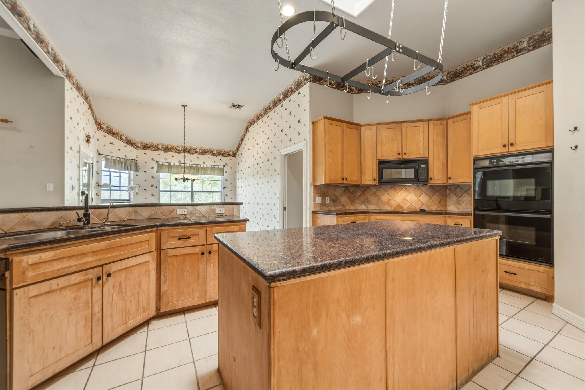 14039 Timberline Trail Austin, TX 78737 - Photo 14 of 39 Kitchen with tasteful backsplash, a center island, black appliances, dark stone countertops, and light tile patterned flooring