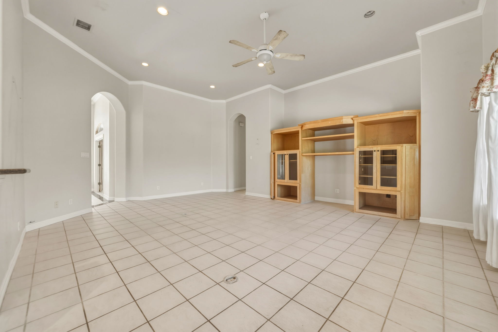 14039 Timberline Trail Austin, TX 78737 - Photo 17 of 39 Unfurnished living room with a ceiling fan, recessed lighting, arched walkways, ornamental molding, and light tile patterned flooring