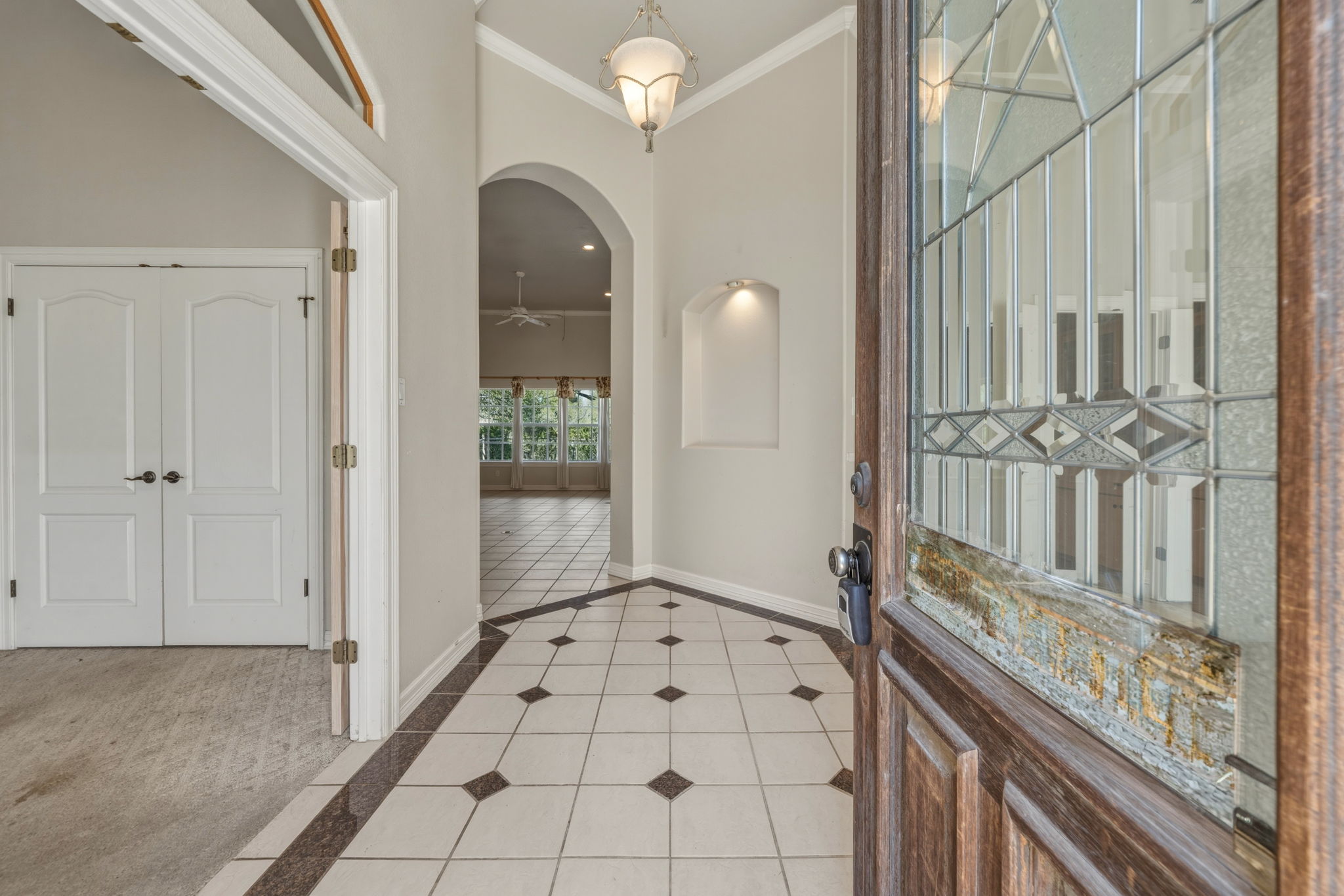 14039 Timberline Trail Austin, TX 78737 - Photo 6 of 39 Entrance foyer with crown molding, arched walkways, light tile patterned flooring, and inlaid floor details