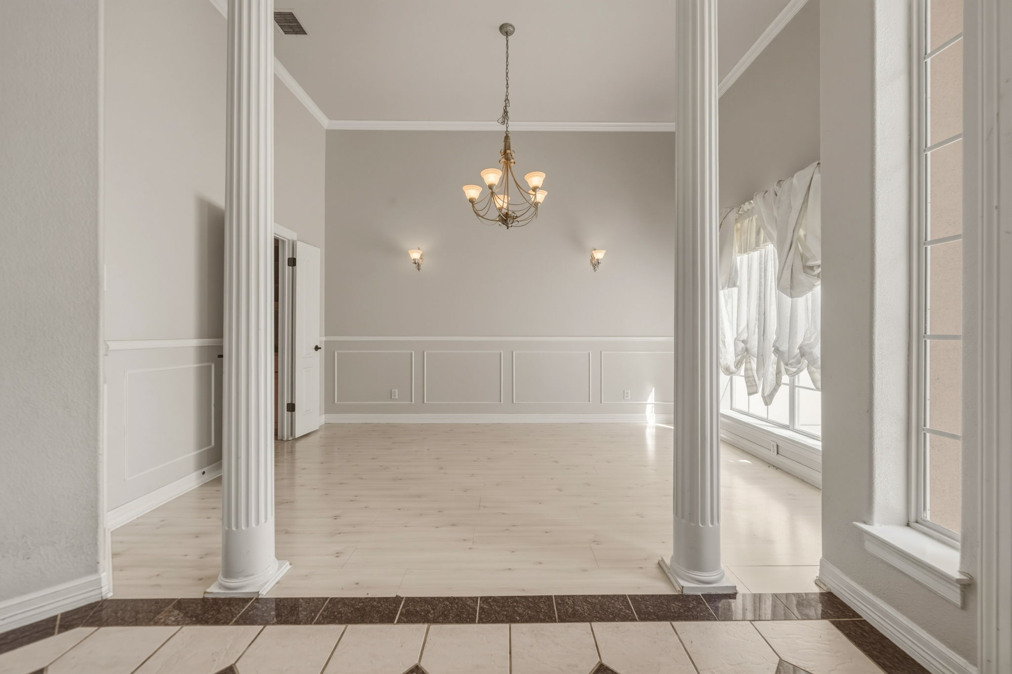 14039 Timberline Trail Austin, TX 78737 - Photo 10 of 39 Unfurnished dining area with hanging lights, inlaid floor details, light tile patterned floors, crown molding, and wainscoting
