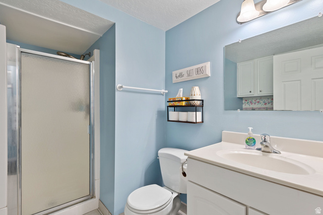 553 North 200 West Bountiful, UT 84010 - Photo 18 of 26 Bathroom with a stall shower, vanity, and a textured ceiling