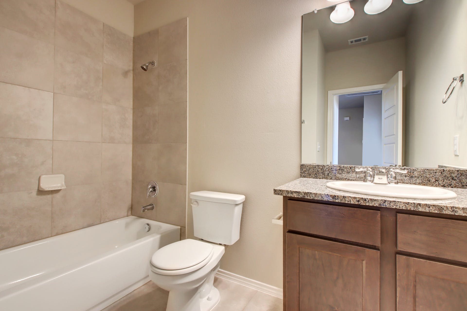 1202 Garland Road Georgetown, TX 78626 - Photo 23 of 28 Bathroom featuring a white bathtub, ceramic tile shower surround, and a toilet