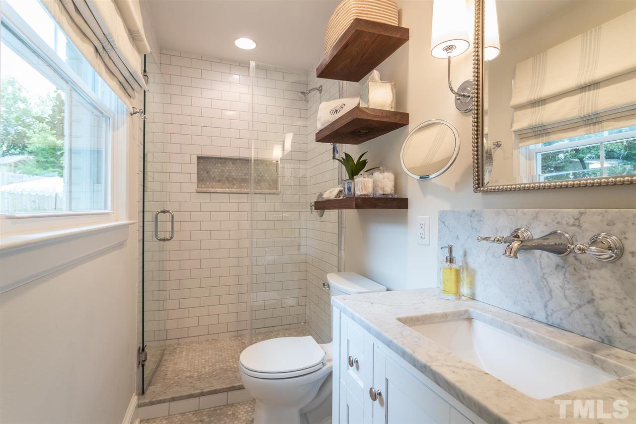 3425 Leonard Street Raleigh, NC 27607 - Photo 22 of 28 a bathroom with a granite countertop sink a toilet and a mirror