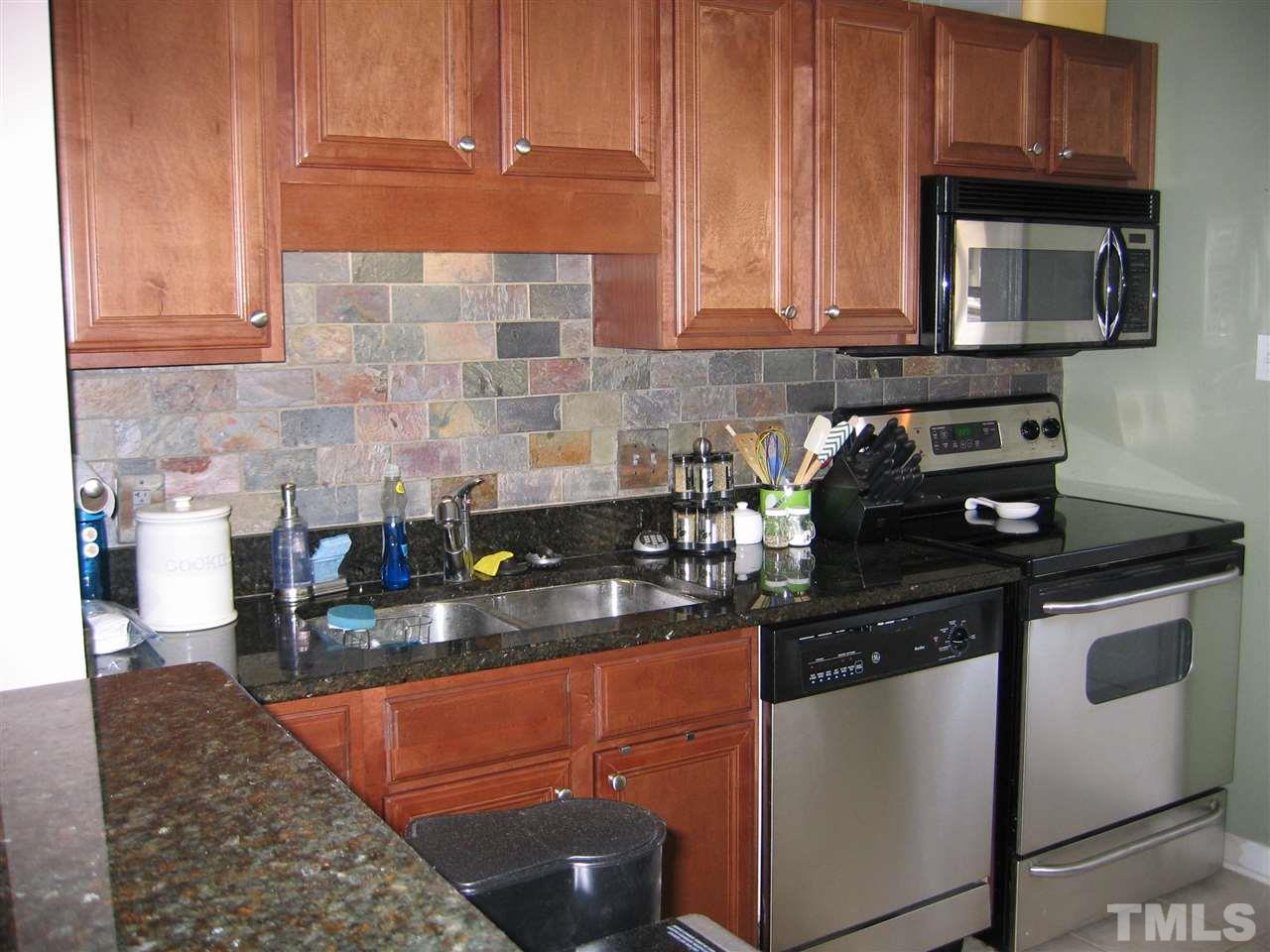 2331 Bernard Street, Unit 2331 Raleigh, NC 27608 - Photo 5 of 12 a kitchen with stainless steel appliances granite countertop a stove a sink and a microwave