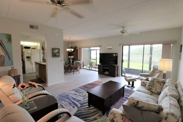 a living room with furniture kitchen view and a large window