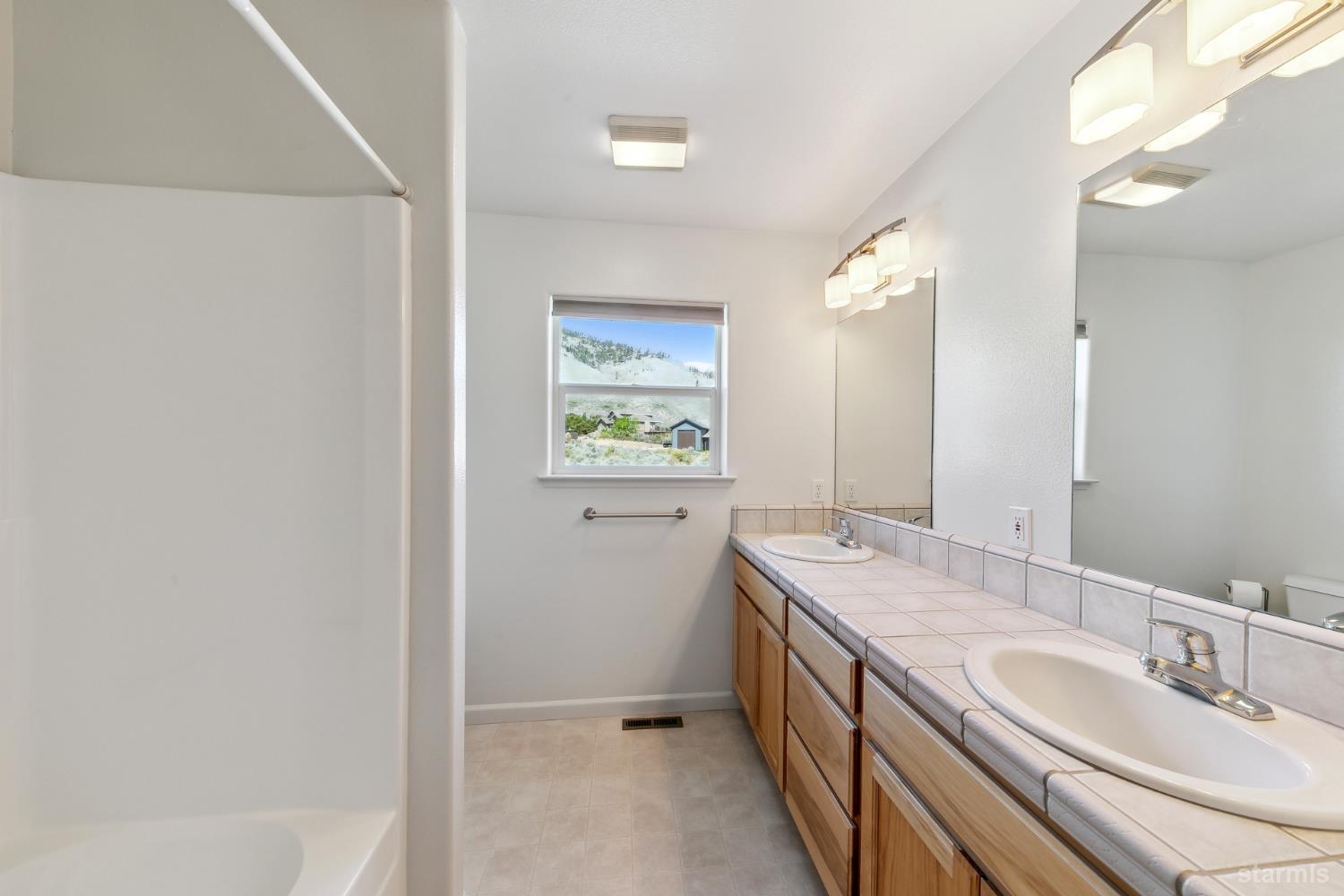 705 Sunrise Trail Markleeville, CA 96120 - Photo 18 of 39 a spacious bathroom with a granite countertop sink a mirror and a