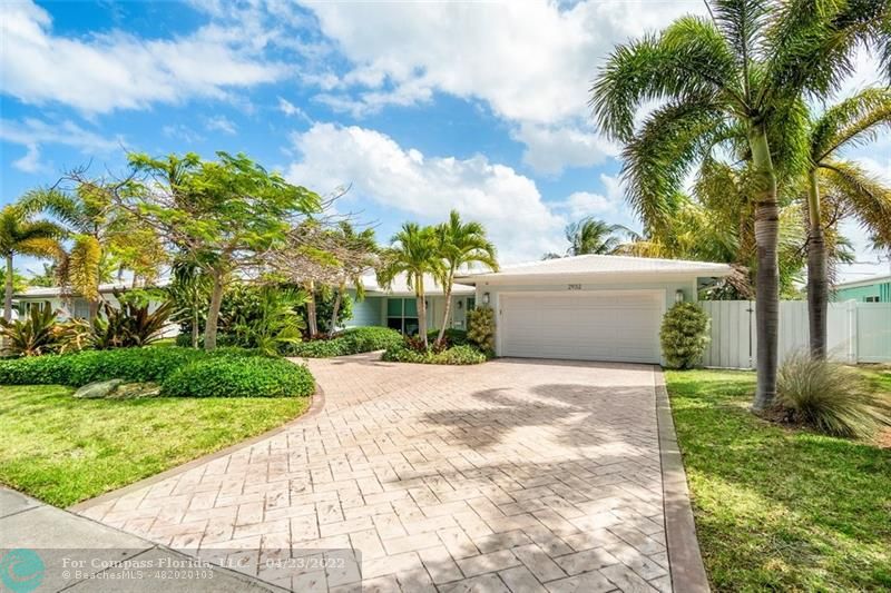 2932 Northeast 36th Street Lighthouse Point, FL 33064 - Photo 2 of 31 a view of a backyard with potted plants and large trees