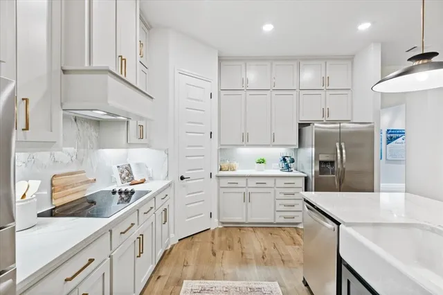 a kitchen with white cabinets stainless steel appliances and sink