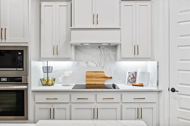 a kitchen with white cabinets and appliances