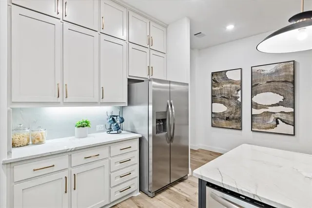 a kitchen with stainless steel appliances cabinets and wooden floor