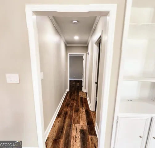 a view of a hallway with wooden floor and entryway