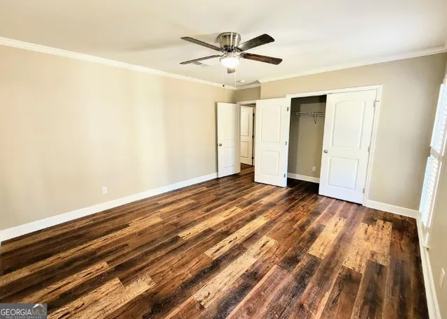 a view of empty room with wooden floor