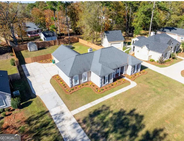 an aerial view of a house with swimming pool and outdoor seating