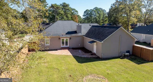 a view of house with yard and trees in the background