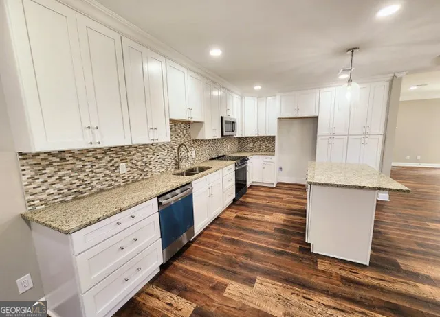 a kitchen with stainless steel appliances granite countertop a sink stove and refrigerator