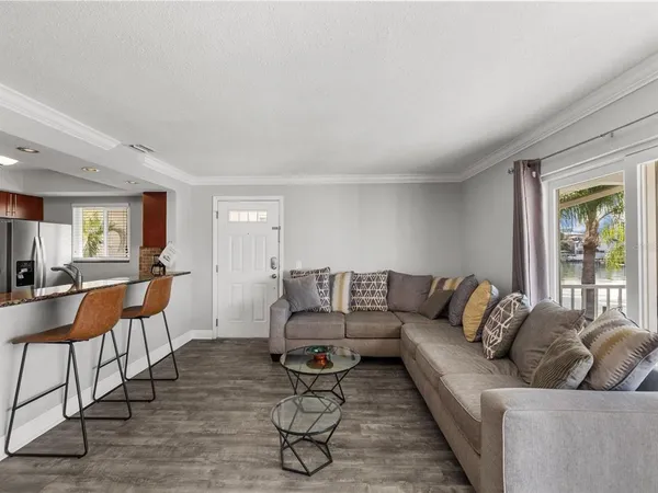 a room with furniture a flat screen tv and kitchen view