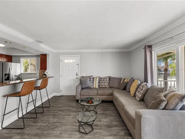 a room with furniture a flat screen tv and kitchen view