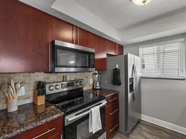 a kitchen island with granite countertop a sink and a refrigerator