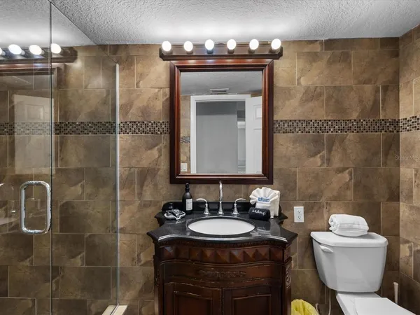 a bathroom with a sink toilet a mirror and shower