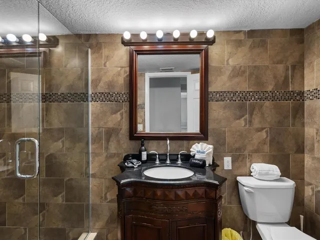 a bathroom with a sink toilet a mirror and shower