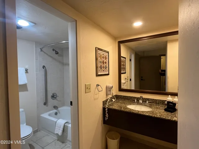 a bathroom with a granite countertop sink toilet and shower