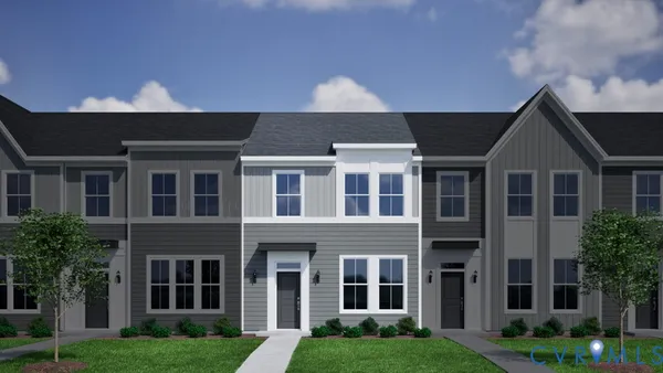 a front view of a residential apartment building with a yard and plants