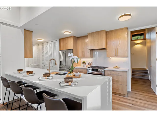a kitchen with a sink a stove and chairs