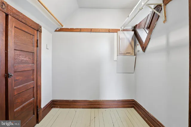 a view of an empty room with wooden floor and stairs
