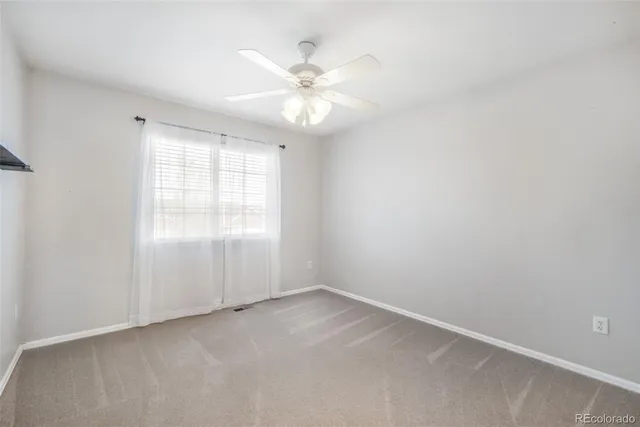 an empty room with fan and entrance