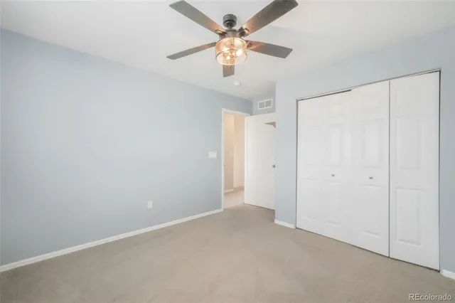 an empty room with a ceiling fan and a window