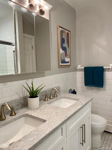 1746 August Road, Unit 1746 North Babylon, NY 11703 - Photo 9 of 10 a bathroom with a granite countertop sink a toilet and mirror