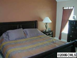6617 Reedy Creek Road Charlotte, NC 28215 - Photo 6 of 8 a bed sitting in a bedroom next to a lamp