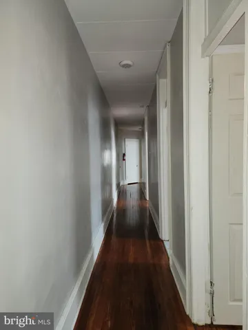 a view of wooden floor and a chandelier fan in a room