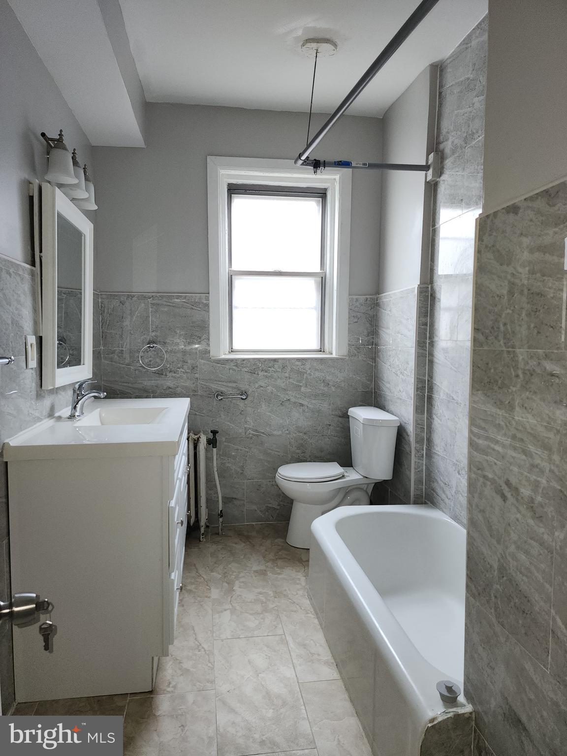 217 South 47th Street, Unit 2 Philadelphia, PA 19139 - Photo 15 of 22 a bathroom with a sink mirror vanity and toilet