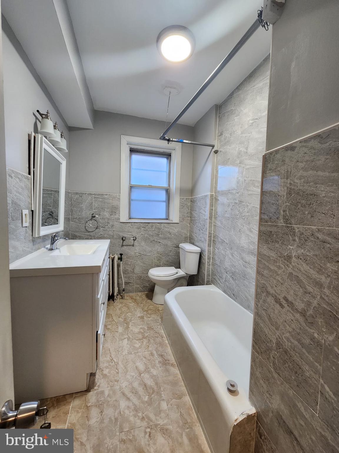 217 South 47th Street, Unit 2 Philadelphia, PA 19139 - Photo 19 of 22 a bathroom with a tub sink and mirror