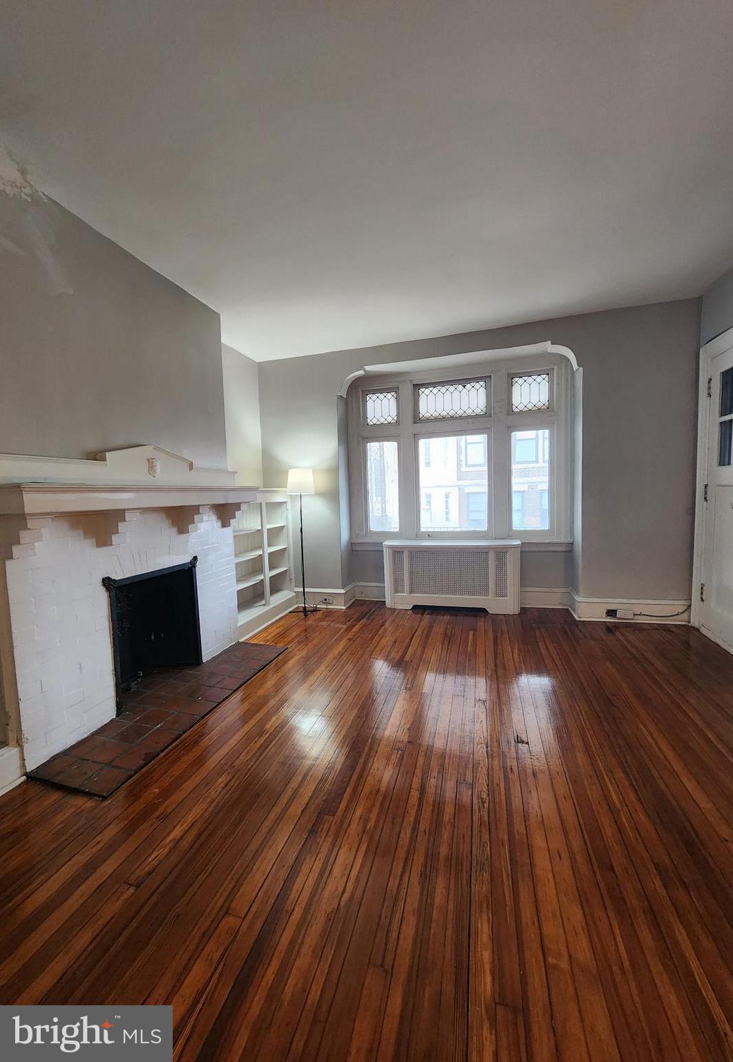 217 South 47th Street, Unit 2 Philadelphia, PA 19139 - Photo 3 of 22 wooden floor in an empty room with a fireplace