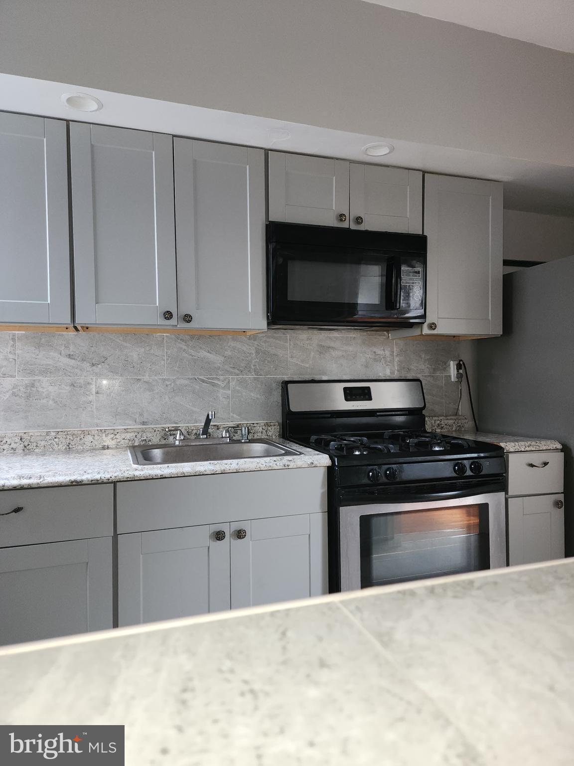 217 South 47th Street, Unit 2 Philadelphia, PA 19139 - Photo 9 of 22 a kitchen with stainless steel appliances granite countertop a stove and a sink