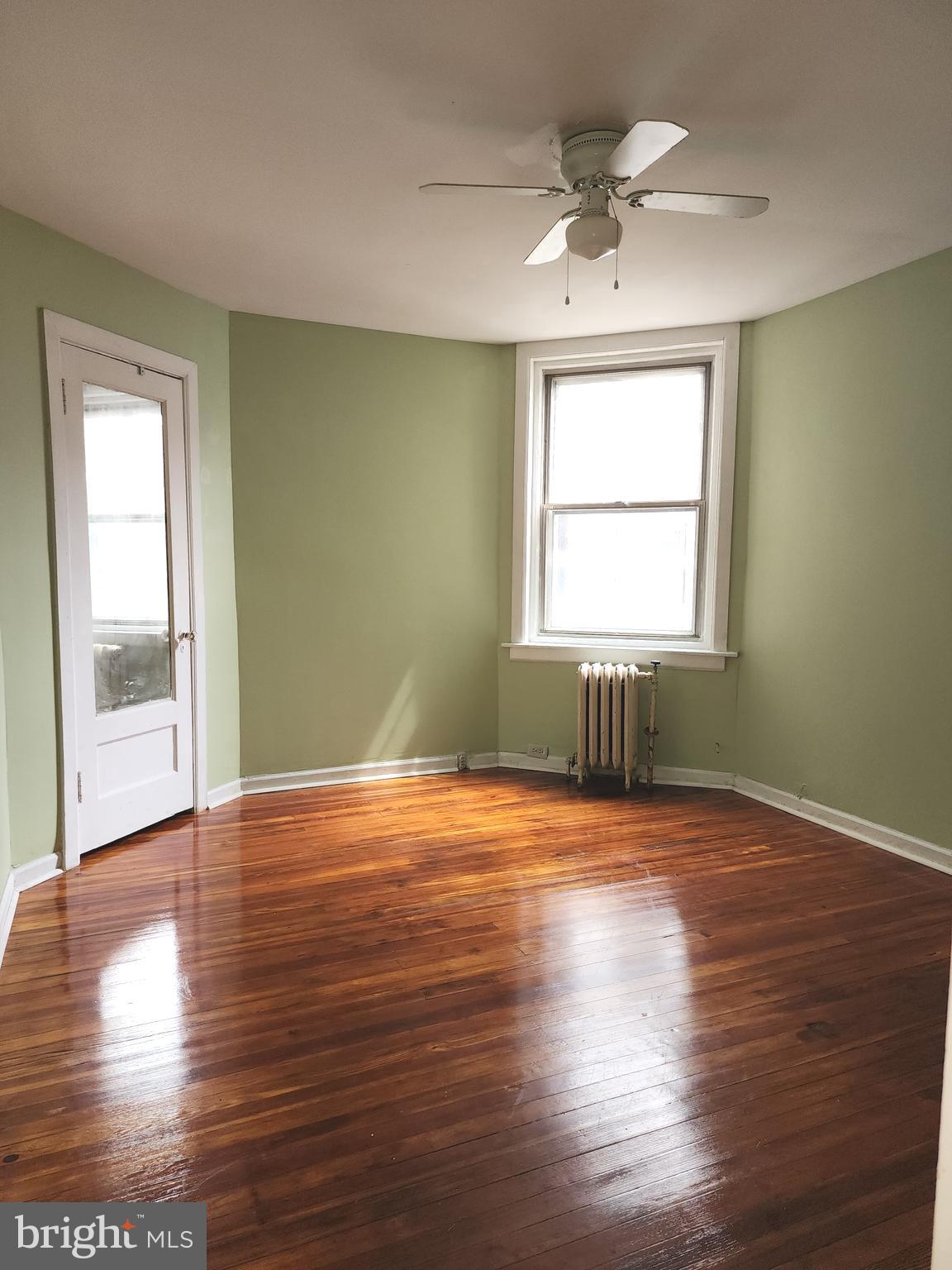 217 South 47th Street, Unit 2 Philadelphia, PA 19139 - Photo 10 of 22 a view of an empty room with wooden floor and a window