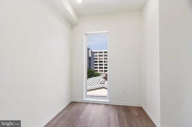a view of an empty room with wooden floor