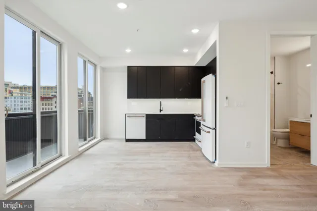 a view of a kitchen with a refrigerator a stove top oven and cabinets