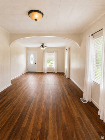 1766 Kenilworth Road Spring Glen, UT 84526 - Photo 5 of 24 Spacious interior featuring wood-finish flooring, an arched doorway, and multiple windows with blinds