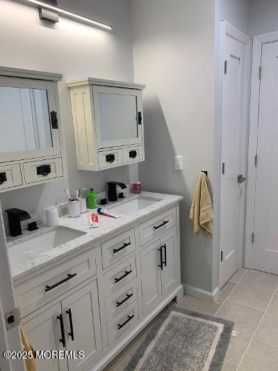 988 Elizabeth Terrace Long Branch, NJ 07740 - Photo 11 of 16 a spacious bathroom with a granite countertop sink and a mirror