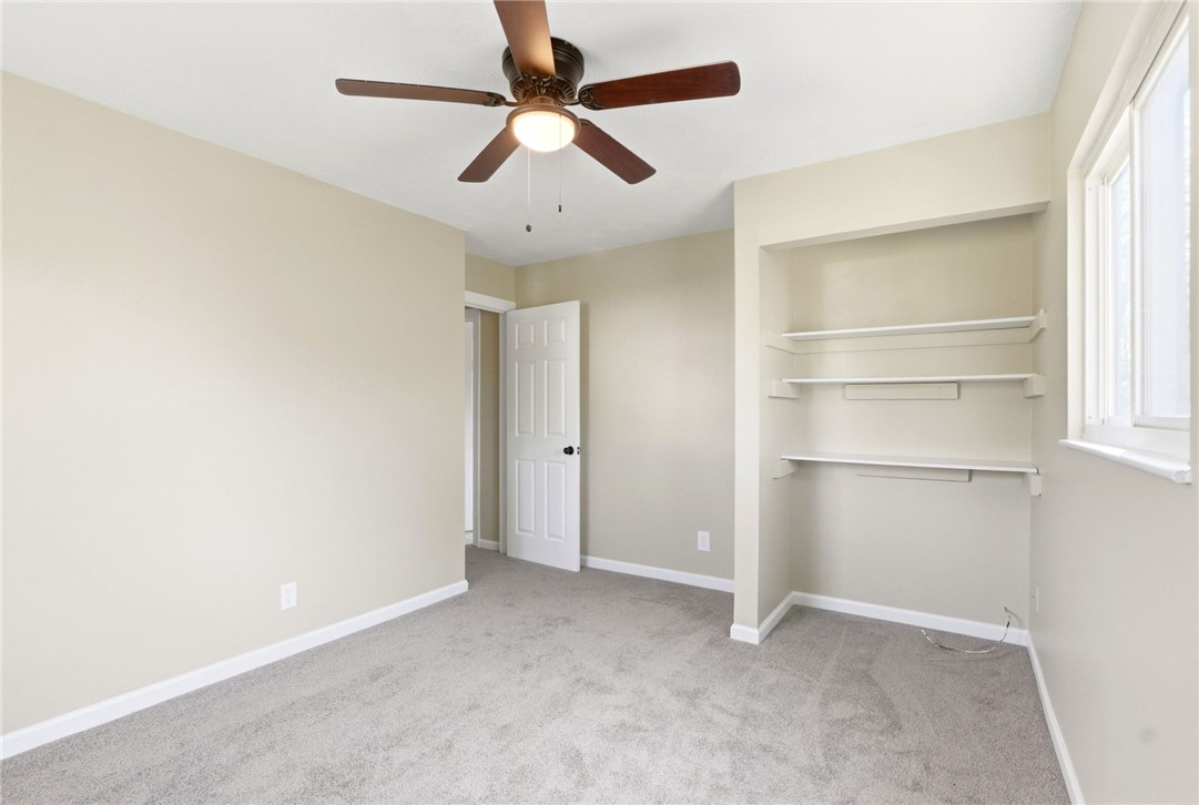 40 Woods Road Springboro, OH 45066 - Photo 44 of 57 This inviting bedroom features soft carpeting, built-in shelving, and a ceiling fan for comfort.